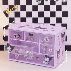 a purple drawer with many drawers and stickers on the front, sitting against a black and white checkered wall