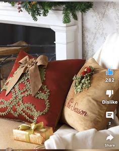 a christmas pillow sitting on top of a couch next to a fire place filled with presents