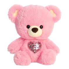 a pink teddy bear with sequins and a heart on it's chest