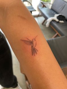 a small bird tattoo on the arm