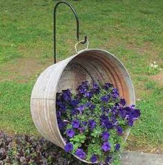 some purple flowers are in a hanging basket