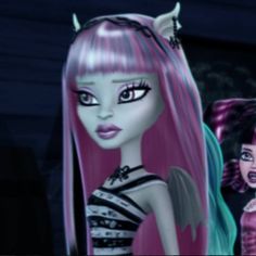 two dolls are standing next to each other in front of a tv screen, one is pink and the other is blue