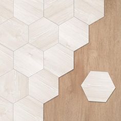 a wooden floor with white hexagonal tiles on it and a piece of wood next to it