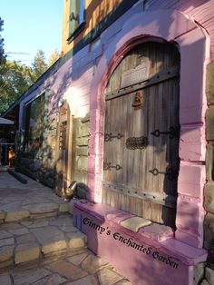 a pink building with a wooden door and window