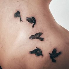 a woman's back with black birds on her lower body and the bottom part of her stomach