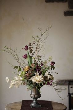 a vase filled with flowers sitting on top of a wooden table