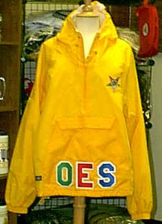 a yellow jacket with the word oes on it hanging from a rack in a store