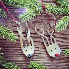 two metal reindeer ornament hanging from a christmas tree