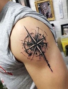 a man with a compass tattoo on his arm