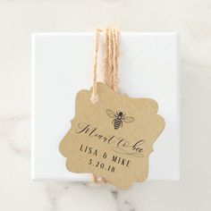 two tags with twine on them are attached to a white gift bag that says meant to be loved