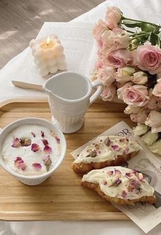 a tray topped with flowers and pastries on top of a table