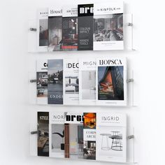 a white wall mounted magazine rack with magazines on it's sides and the words decagoa written in spanish