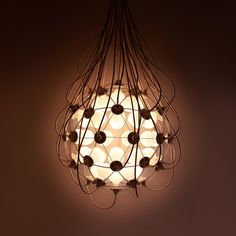 a light hanging from the ceiling with many lights on it's sides and circles in the center