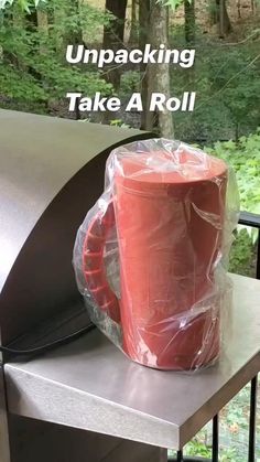 a red cup wrapped in plastic sitting on top of a grill