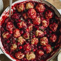 meatballs covered in cranberry sauce and garnished with herbs