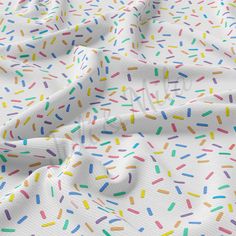 a white fabric with multicolored sprinkles on the top and bottom