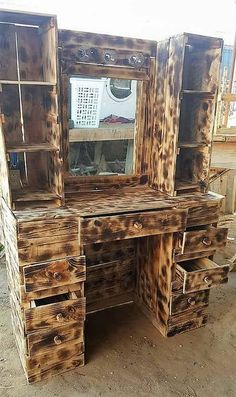 an old wooden desk with drawers and mirror