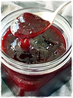 a spoon full of jam sitting on top of a jar