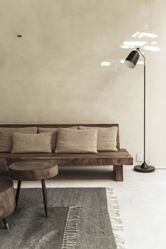 a wooden couch sitting next to a lamp on top of a table in a living room