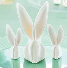 three white bunny ears sitting on top of a green plate