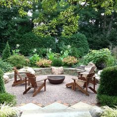 an outdoor seating area with chairs and fire pit surrounded by trees, bushes and shrubs