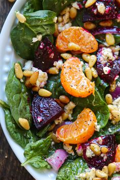 a white plate topped with salad and oranges