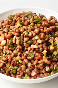 a white bowl filled with beans and vegetables