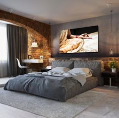 a bedroom with brick walls and a large painting on the wall above the headboard