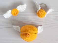 three crocheted items are arranged on a white surface, including an angel keychain