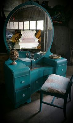 a blue vanity with a mirror and stool