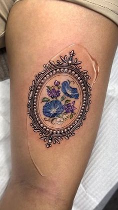 a close up of a person's leg with a flower tattoo on the thigh