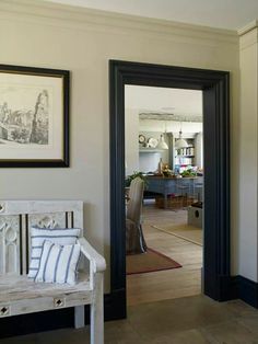 an image of a living room with pictures on the wall and a bench in front of it