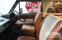 the interior of an old car with leather seats and a stop sign on the wall