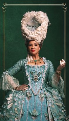 a woman in a blue dress and hat with feathers on her head is posing for the camera