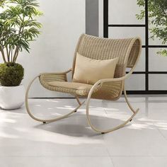 a chair sitting next to a potted plant on top of a white tile floor