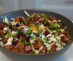 a close up of a bowl of food with meat and vegetables in it on a table