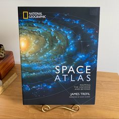 a book sitting on top of a wooden table next to a clock and other items