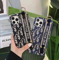 two phone cases with the words christmas and new year printed on them, one is holding a keychain