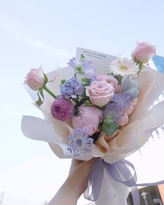 a person holding a bouquet of flowers in their hand