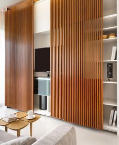 a living room filled with furniture and wooden slats on the wall next to a flat screen tv