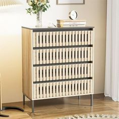 a white and black cabinet sitting on top of a wooden floor next to a lamp