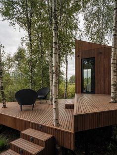 a wooden deck surrounded by trees and stairs