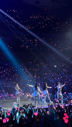 a group of people standing on top of a stage in front of a large crowd