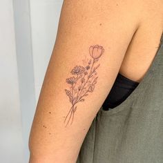 a woman's arm with a flower tattoo on the left side of her arm