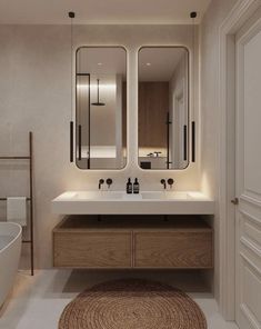 a bathroom with two sinks, mirrors and a rug on the floor in front of it