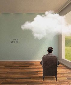 a man sitting in a chair looking at a cloud floating over his head on the wall