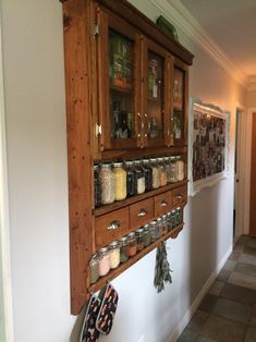 a wall mounted spice rack with jars and spices on it's sides in a kitchen