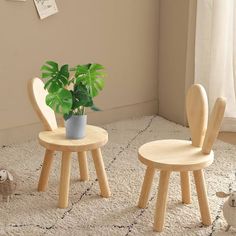 two children's wooden chairs with plants on the floor next to each other in front of a window