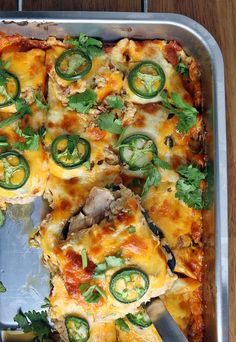 a metal pan filled with pizza covered in cheese and veggies