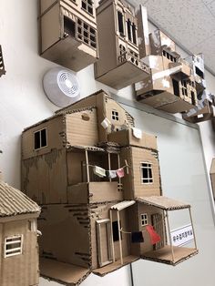 several cardboard houses are hanging on the wall